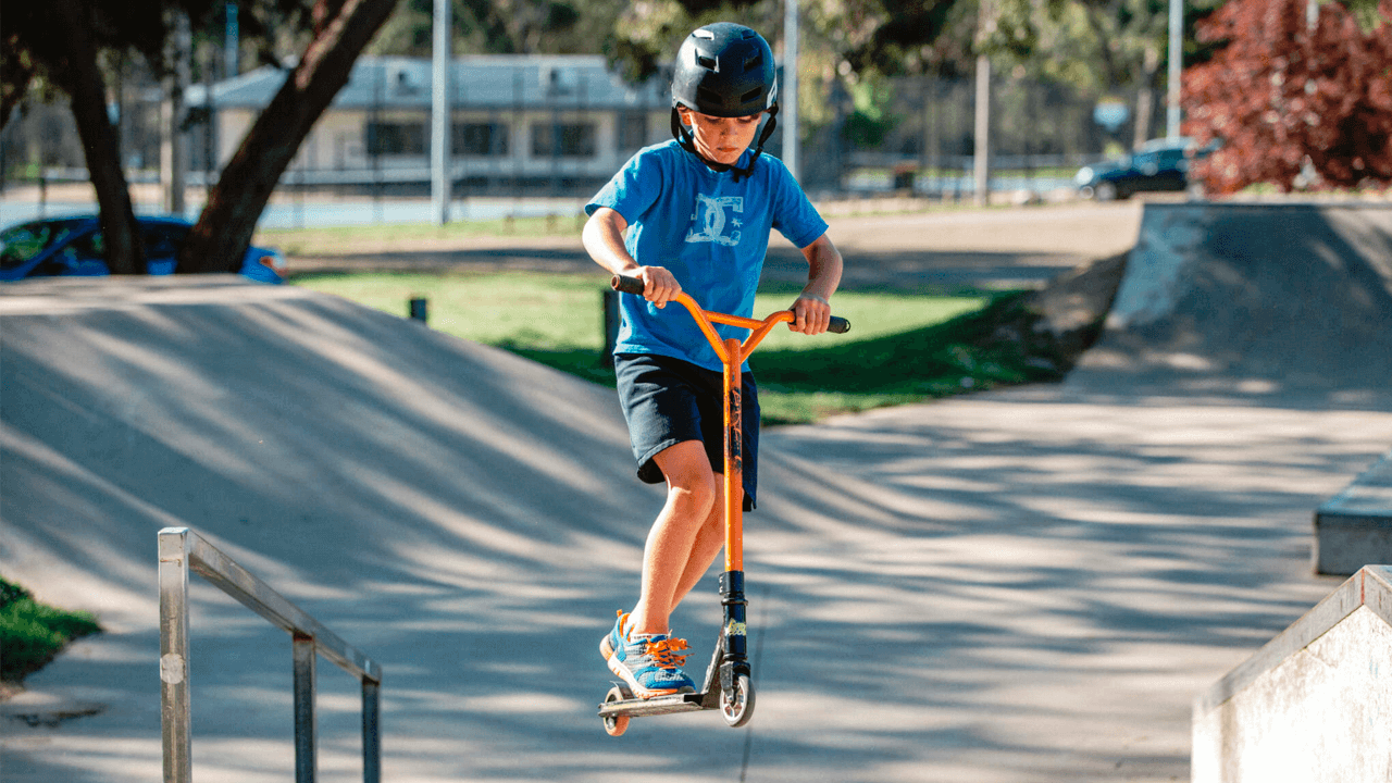 Ребенок на трюковом самокате Ребенок на трюковом самокате